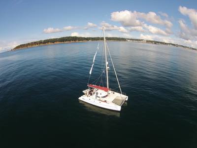 Aerial shot of Fontaine Pajot Athena 38 catamaran anchored in St Aubin's bay Jersey