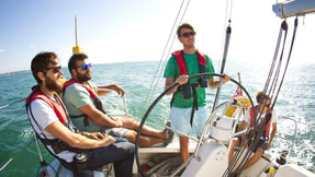 Group enjoying sunshine sailing on a RYA Day Skipper course